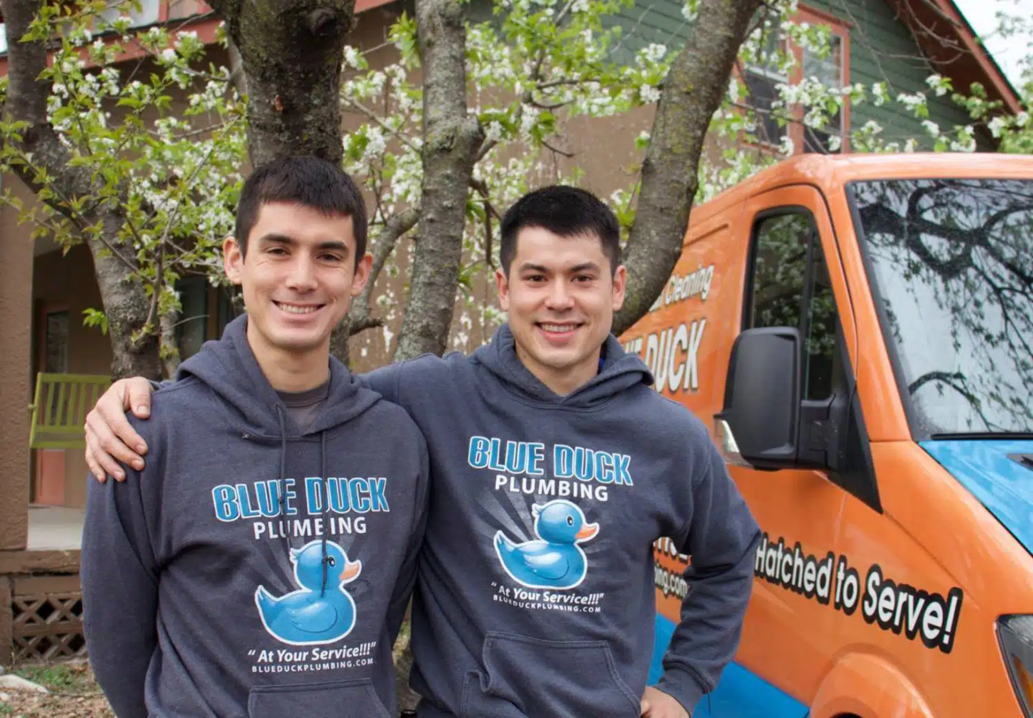 Two Blue Duck techs standing in front of a truck